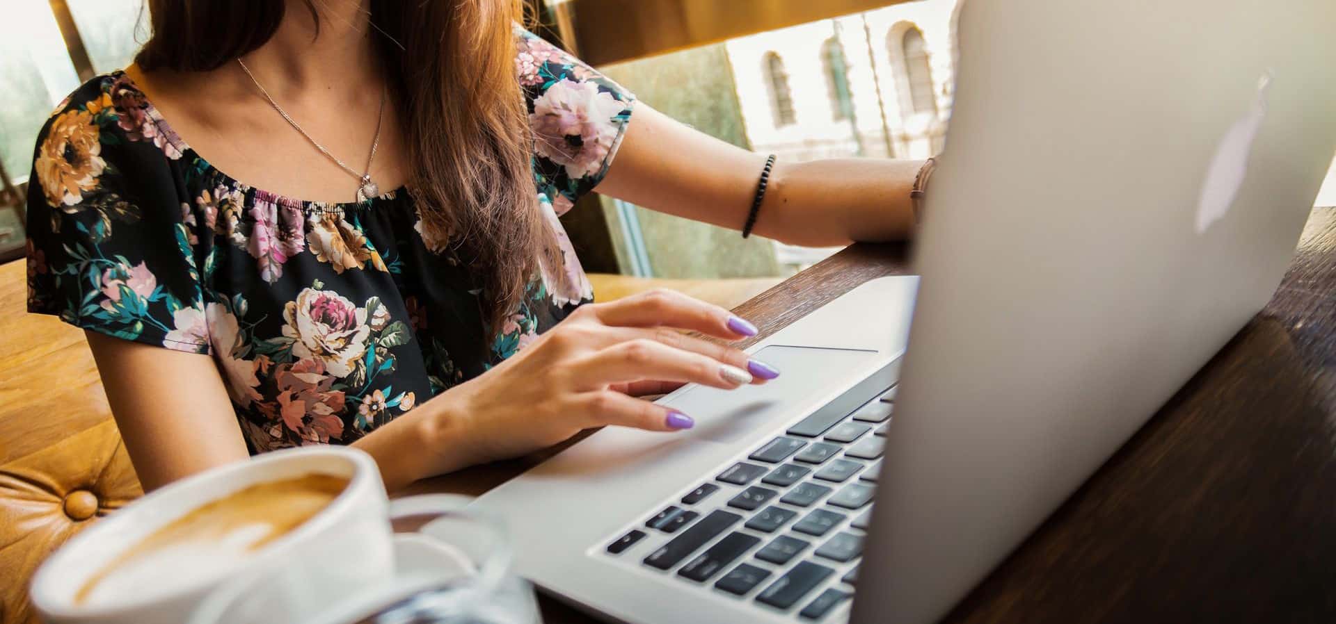 Woman typing with coffee